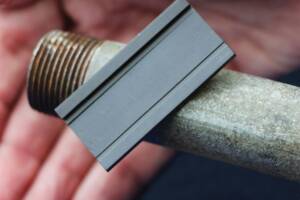 Galvanized steel pipe with a magnet attached.